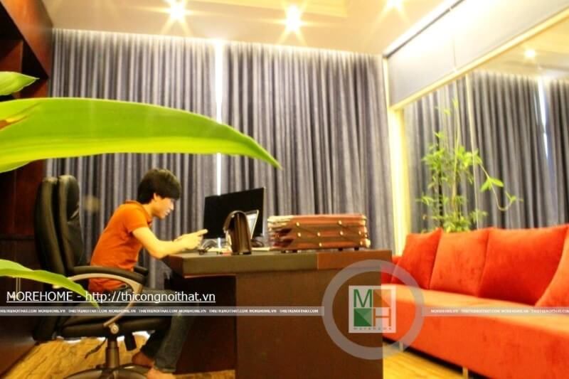 Phòng giám đốc được trang bị với một bộ sofa bành màu đỏ, một bàn làm việc, một kệ tài liệu chạm trần và những đồ nội thất khác.
